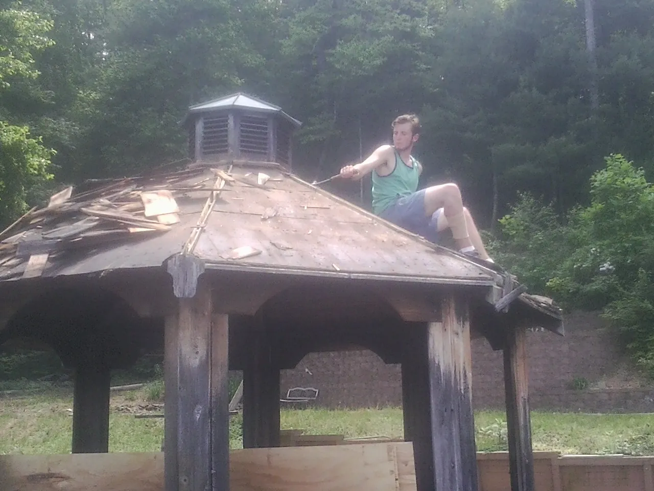 Tearing the old roof off a wooden gazebo before new shakes in Springwater