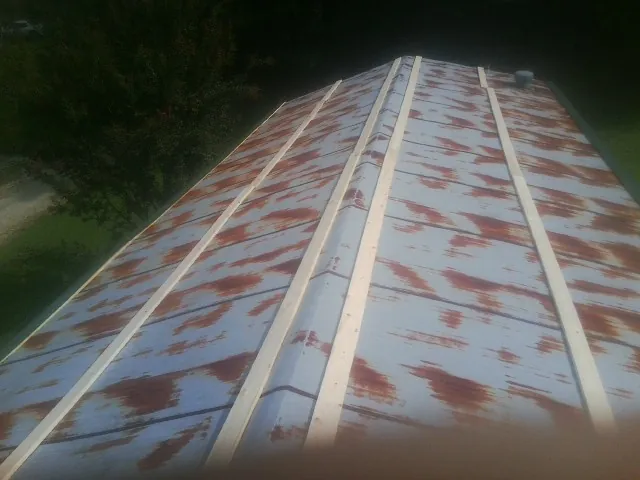 Rusted metal roof panels with new wood purlins before replacement — Storm Damage Roof Repair in Springwater by Roofing Brothers