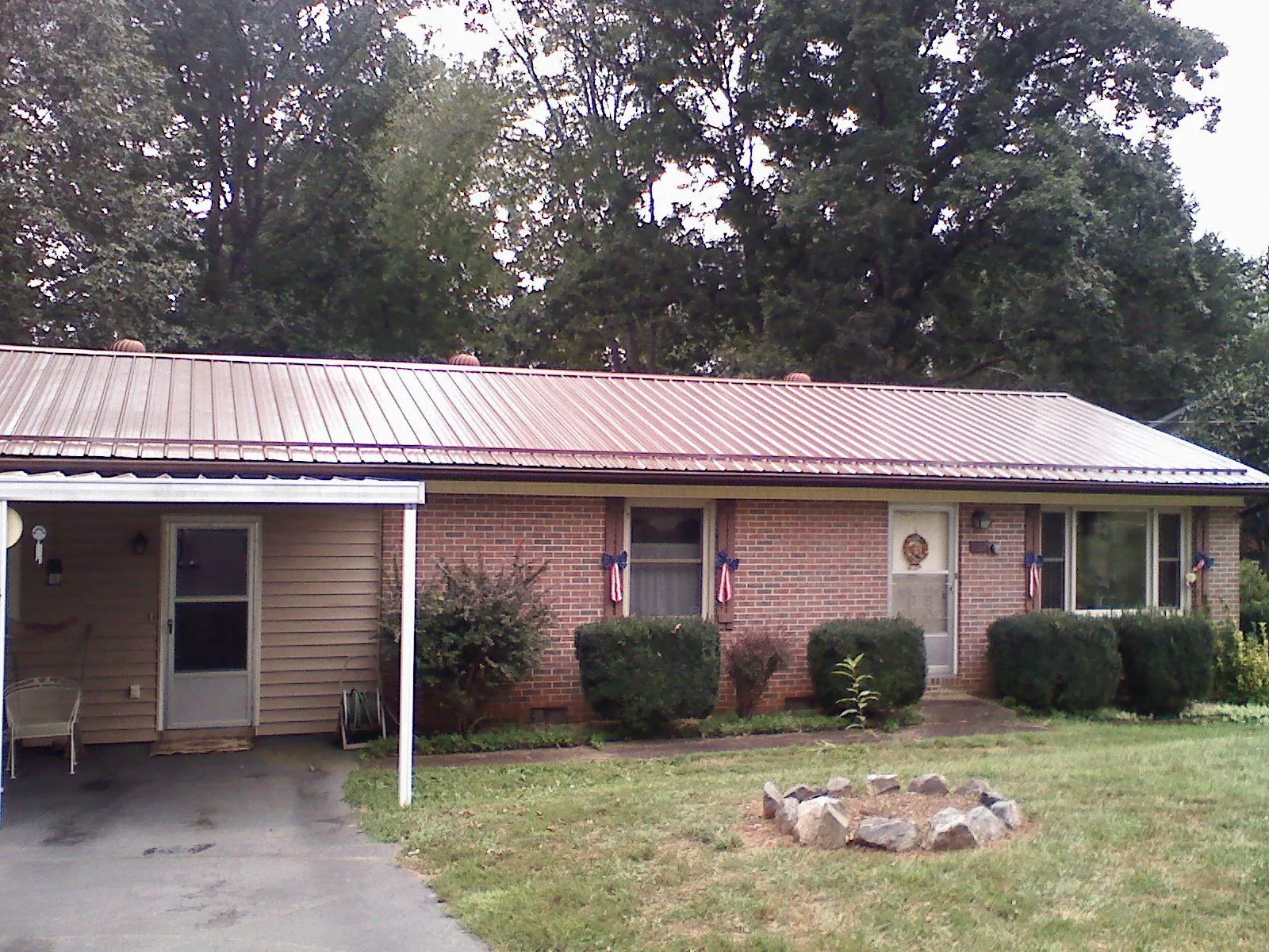 Bronze metal roof and carport on a brick ranch home — Roof Repair work by our crew in Springwater